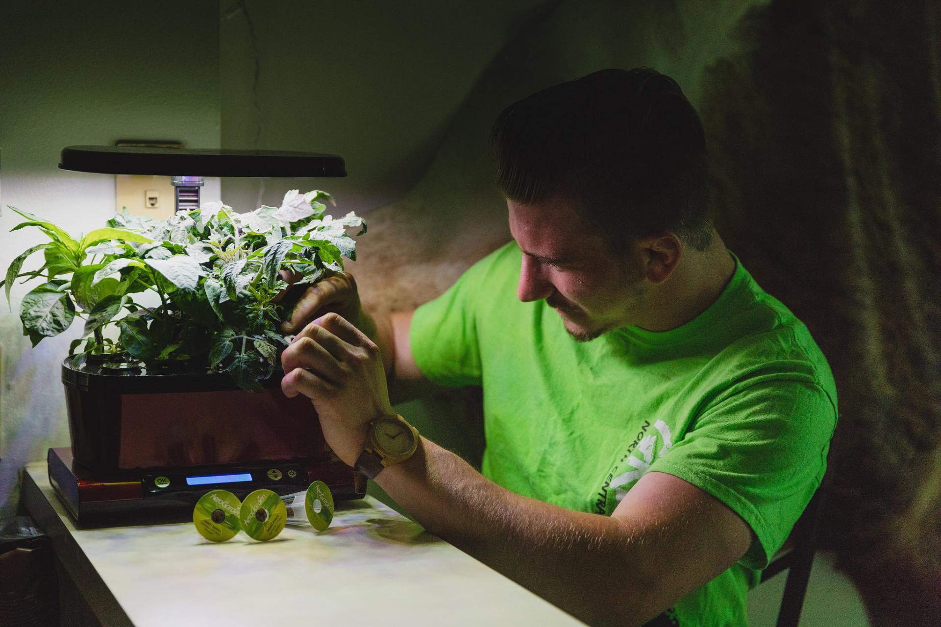 Brandon Malone works on the hydroponic unit in his home.