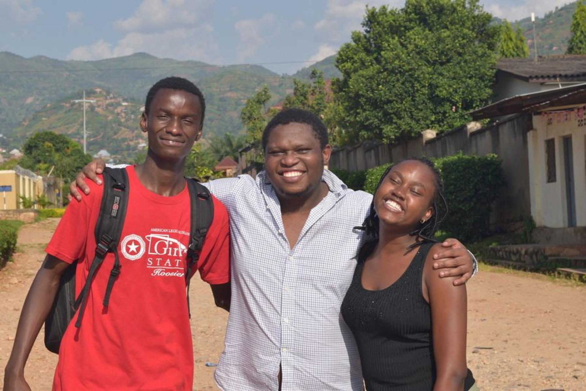 Gates Cambridge Scholar Etienne Mashuli poses with two of his students.