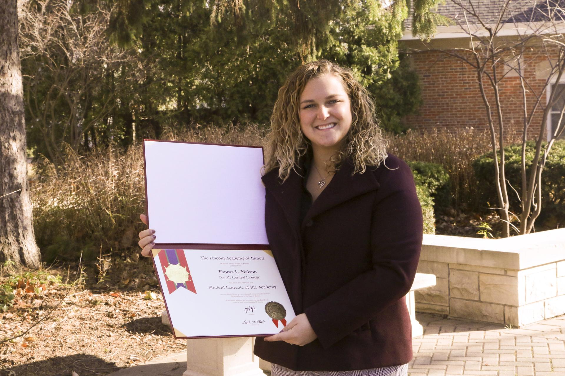 Emma Nelson holds her certificate for being North Central College's 2020 Lincoln Laureate.