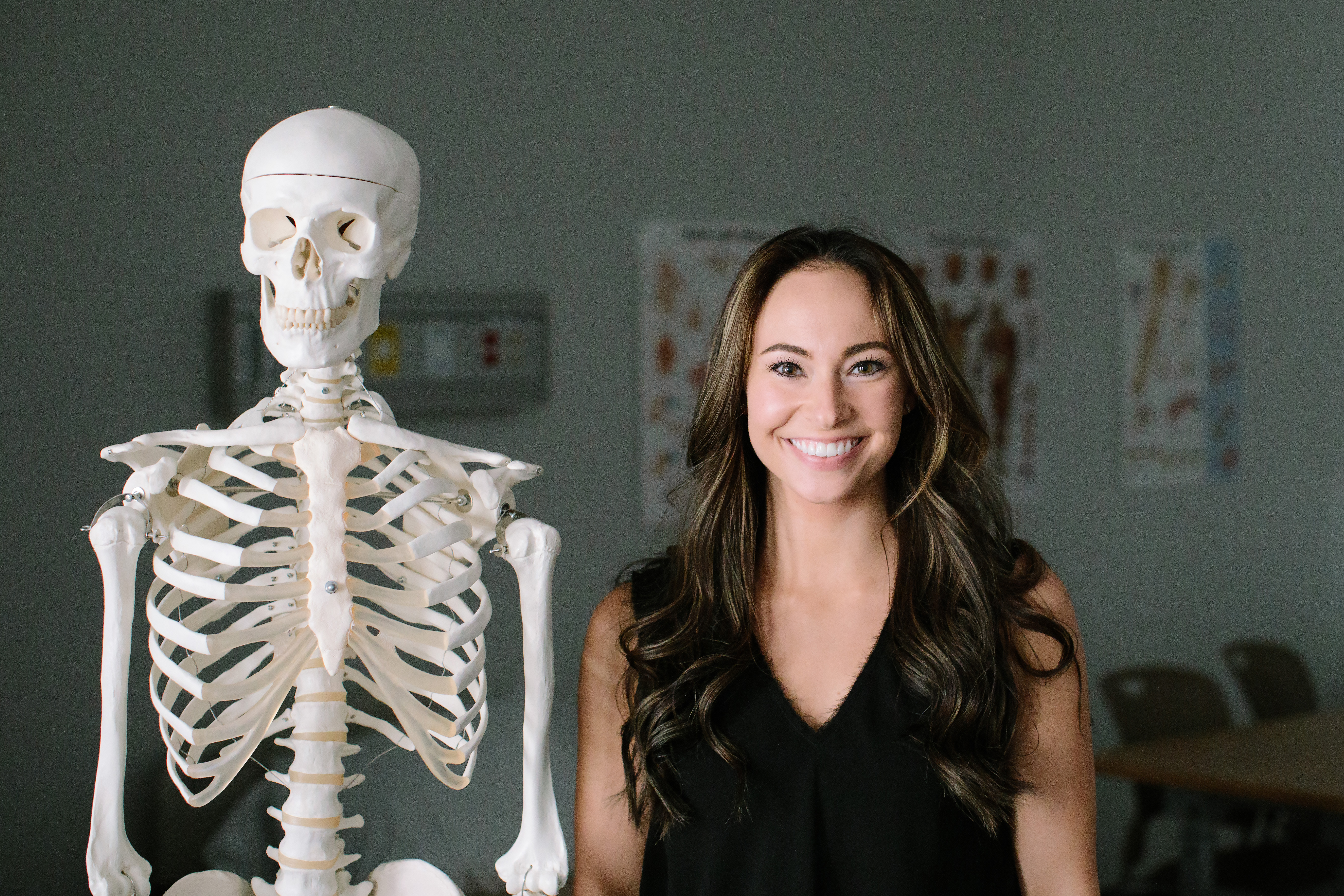 student standing next to skeleton