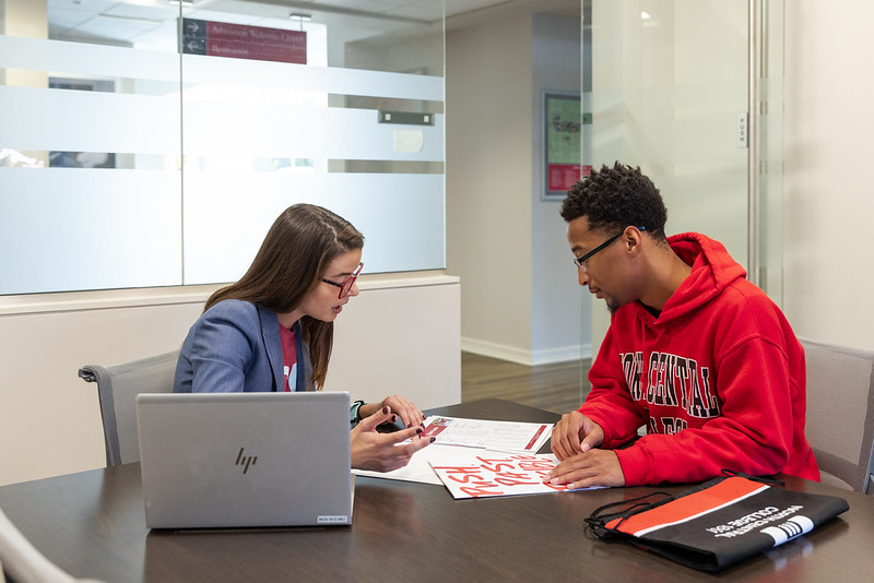 Admission counselor sitting with student in a conference room