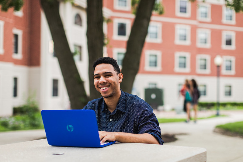 student sitting outside on laptop