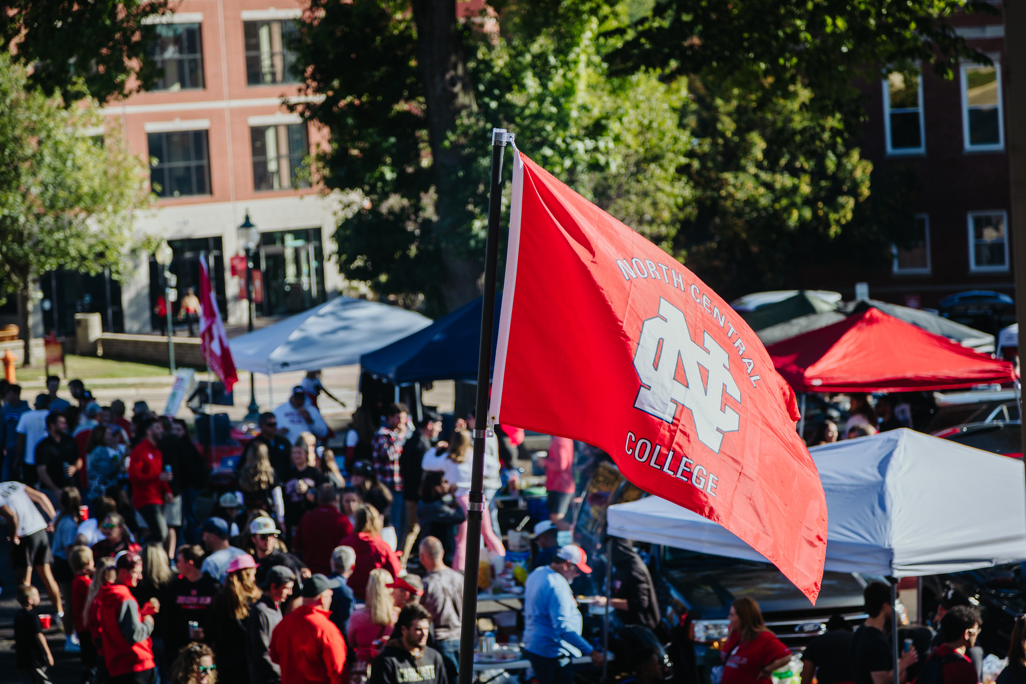 The North Central College flag being waved in the tailgates at Homecoming.