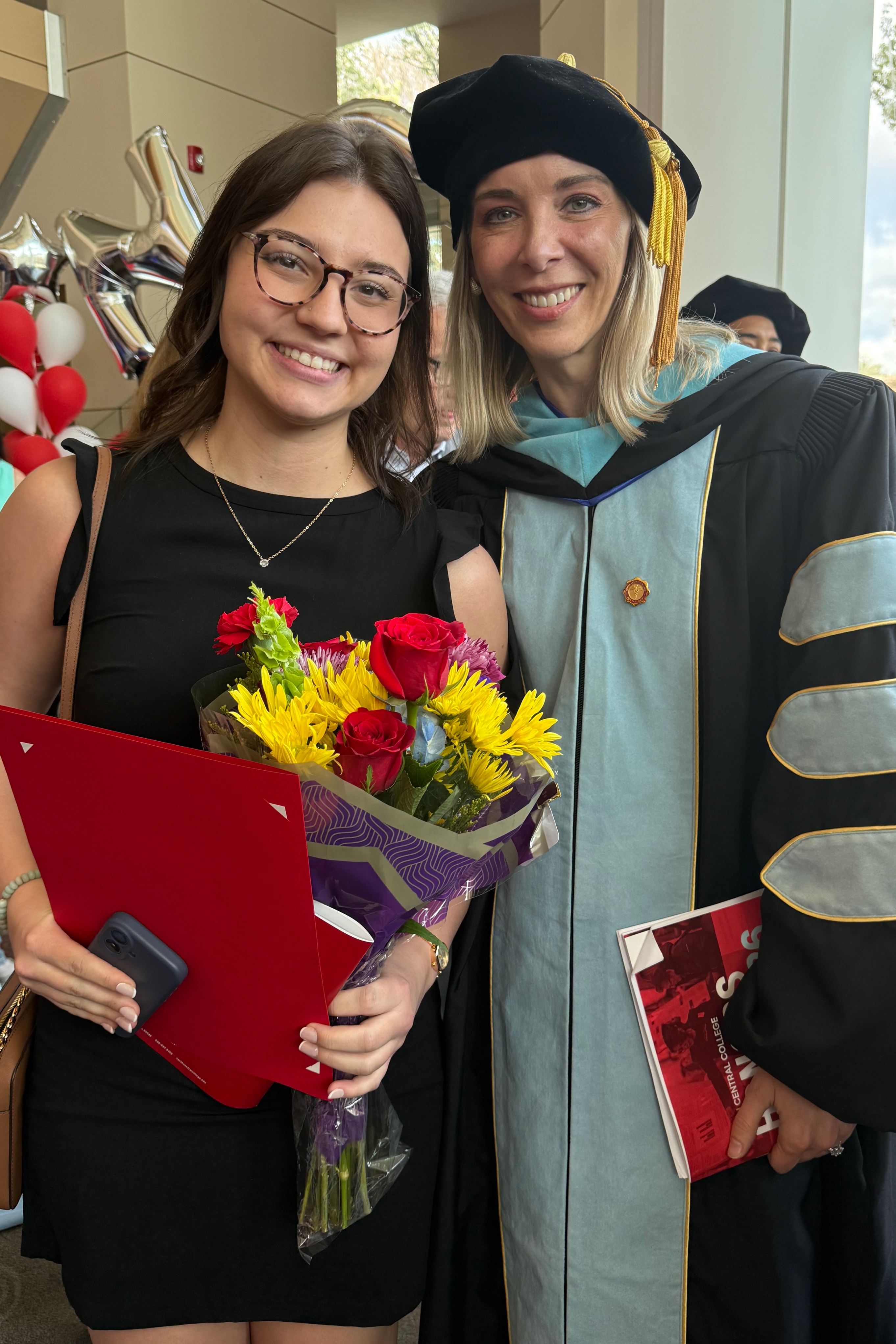 Logan and her mentor Dr. Kristin Patel are posing for a photo at a Commencement event.