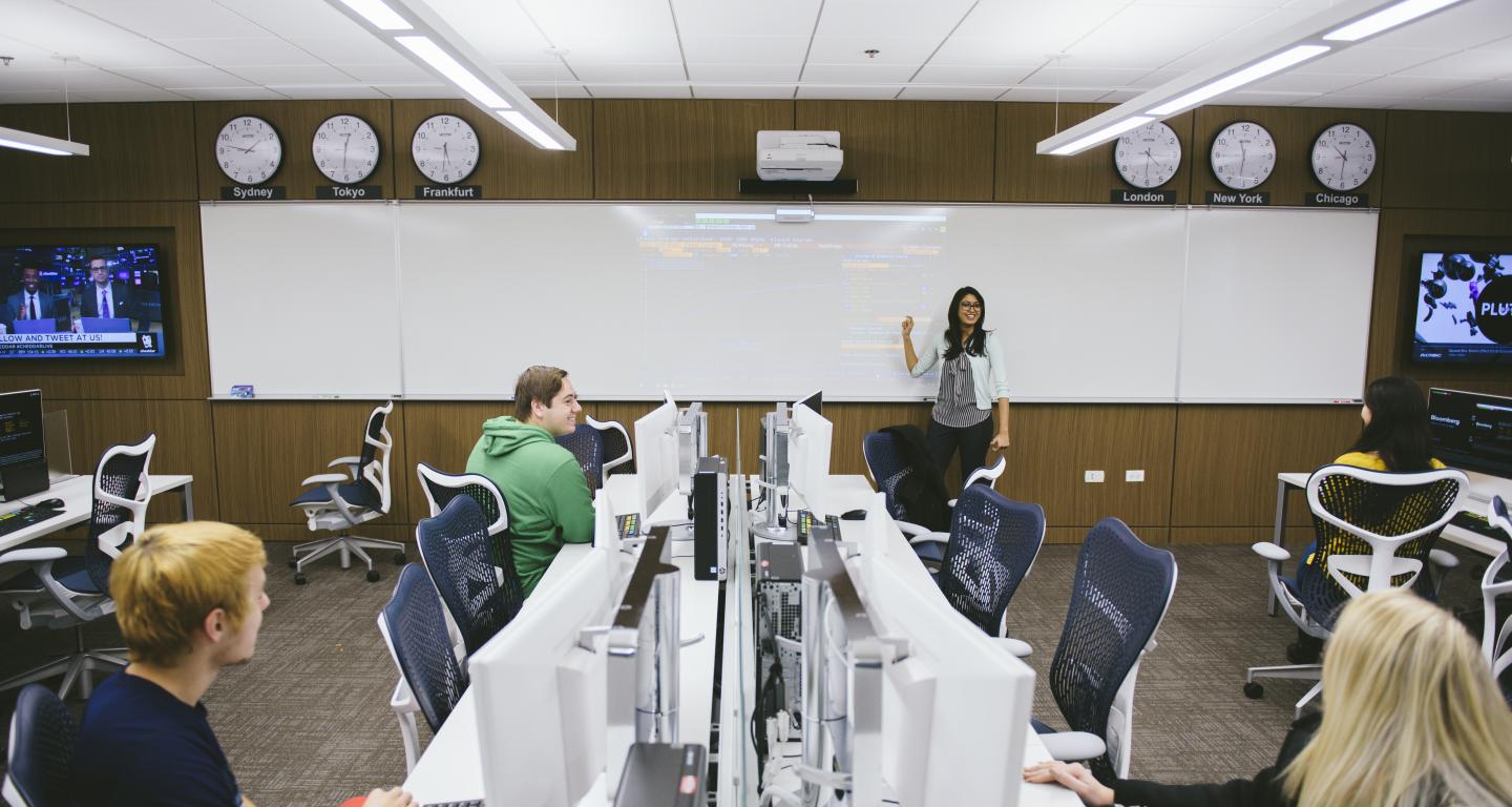 Professor talking in front of class in Bloomberg finance lab