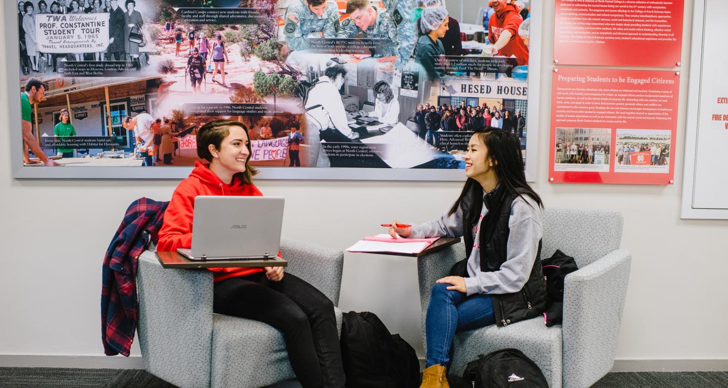 Two students taking a webinar in the hallway of the School of Business and Entrepreneurship at North Central College.