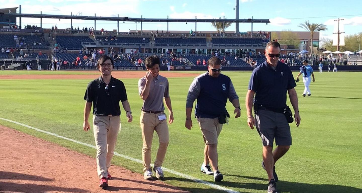 Shota Sato and Seattle Mariners' athletic trainers walk on the field
