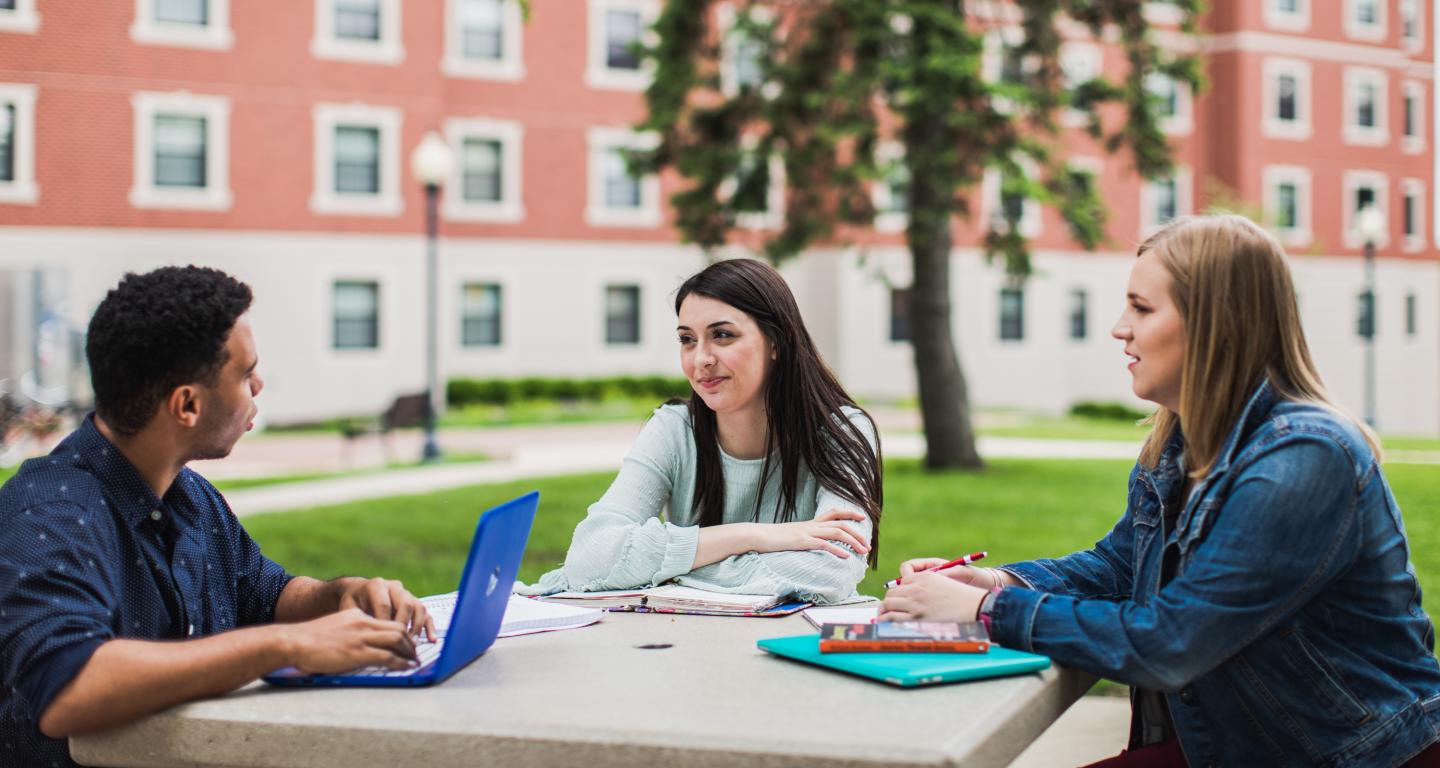 students sitting outside on campus