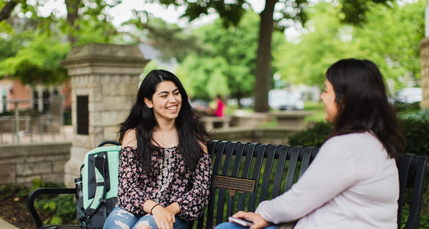 students talking on a bench