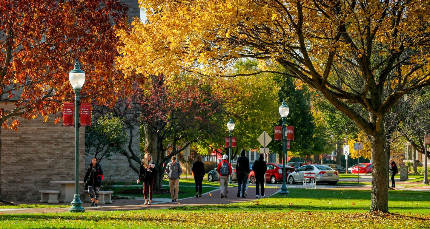 Students walking on campus in the fall