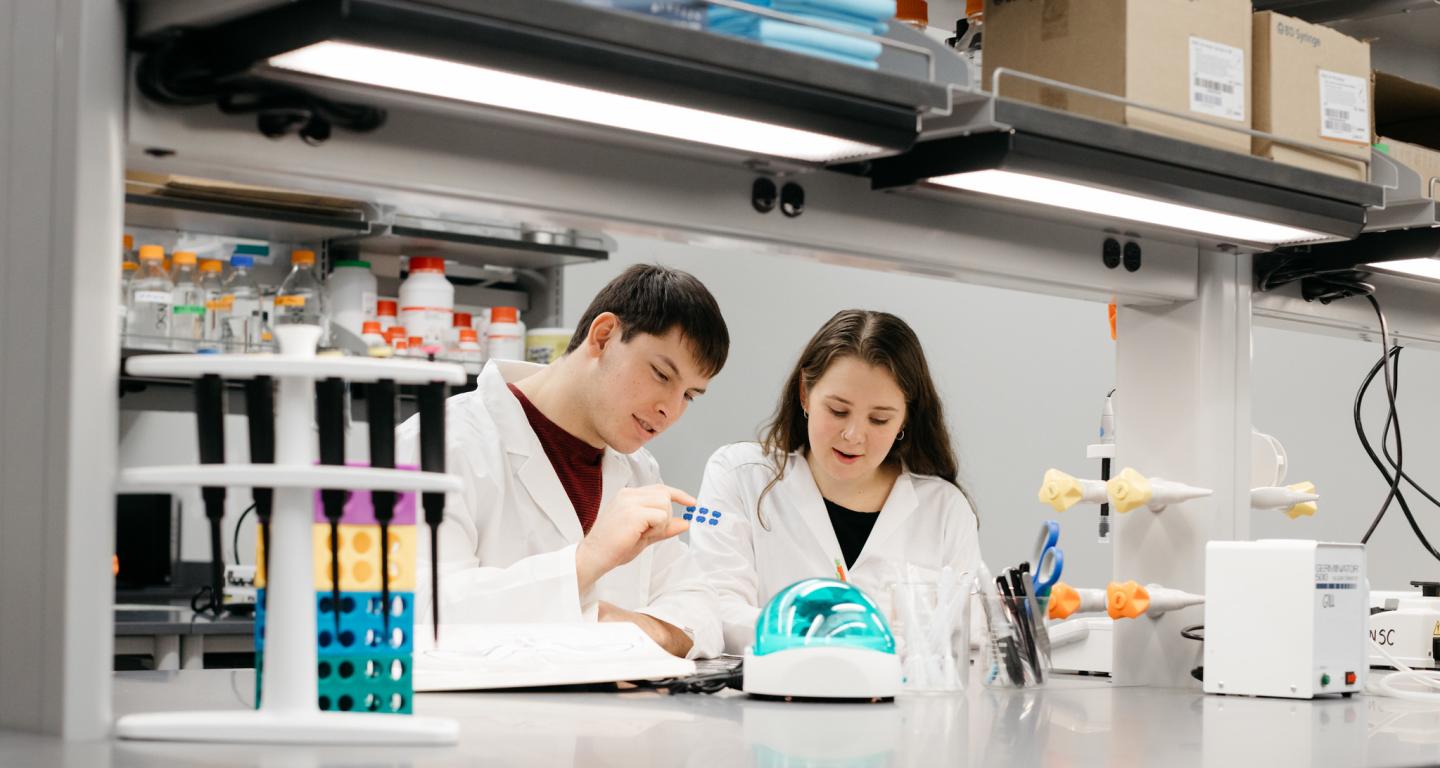 Two biology students working in a lab.
