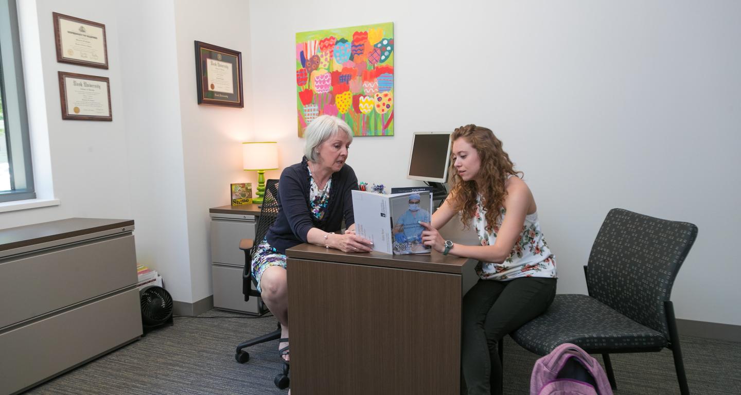 A pre-health coordinator discusses pharmacy programs with a stuent.