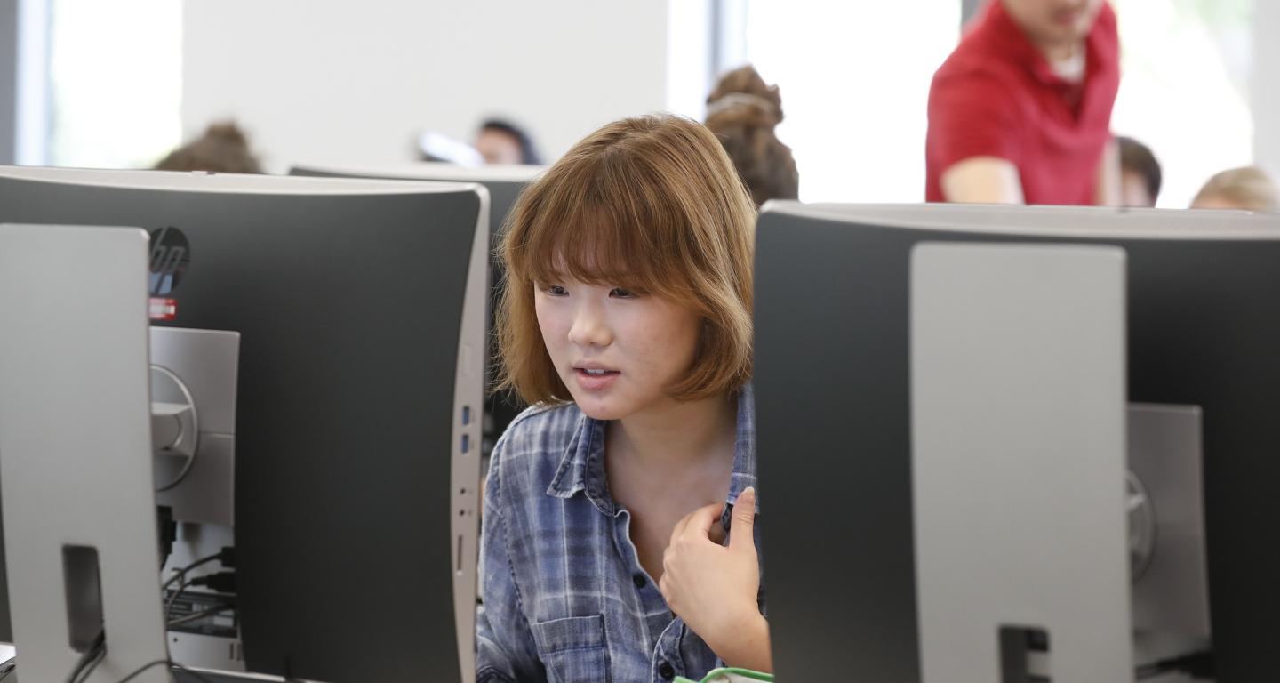 A student at a computer researching schools like North Central College.