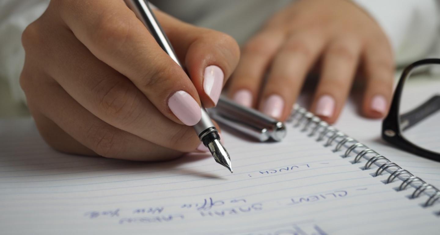 The hands of a North Central College student as she writes out her schedule.