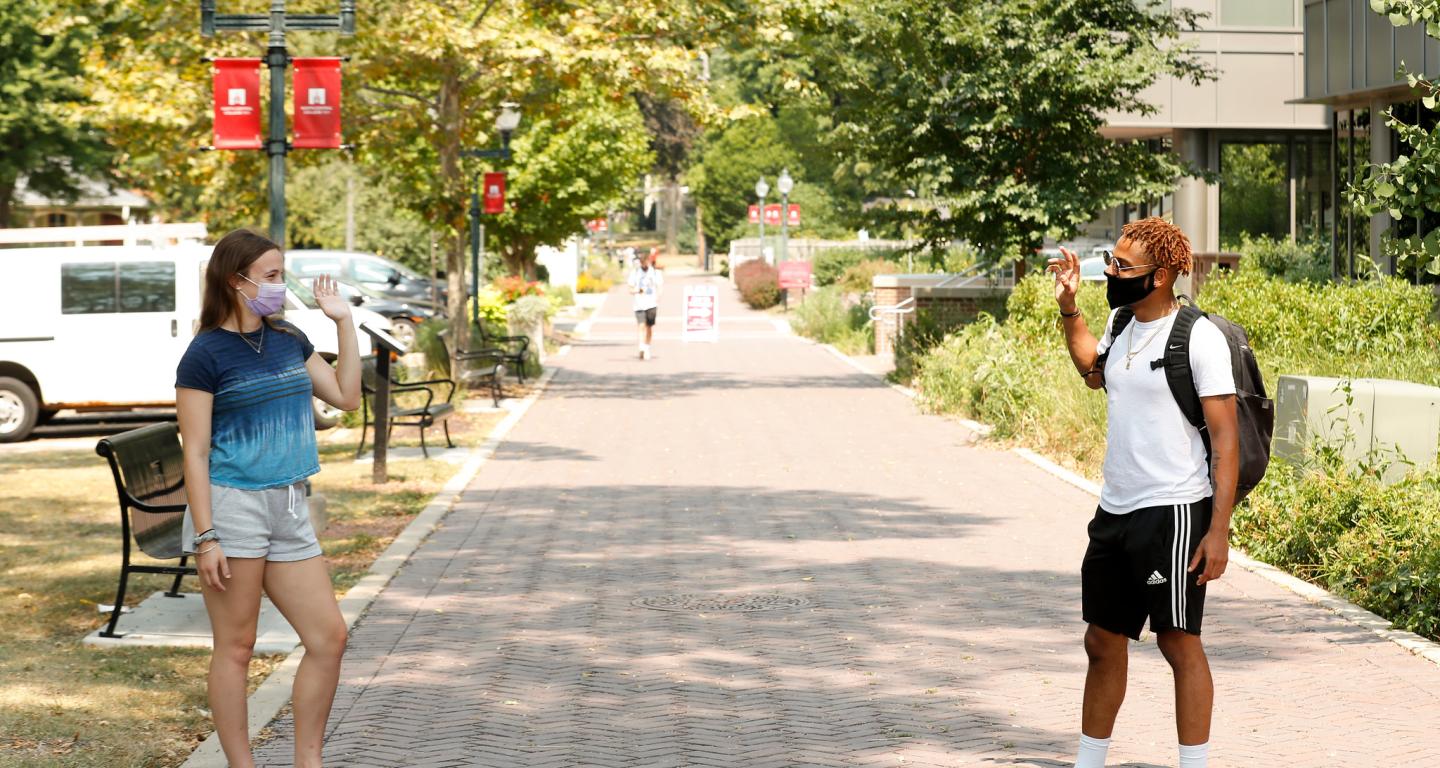 North Central College students and friends greet each other from a social distance.