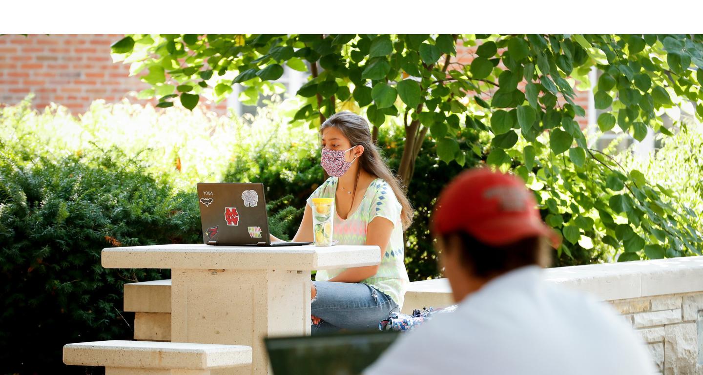 A North Central College MBA student working on an assignment outside.