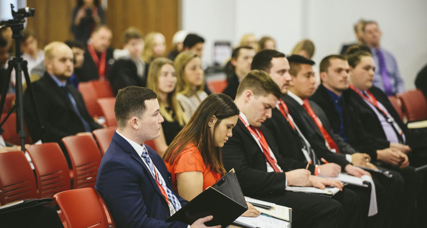 Human resource management students at North Central College taking notes at a conference.