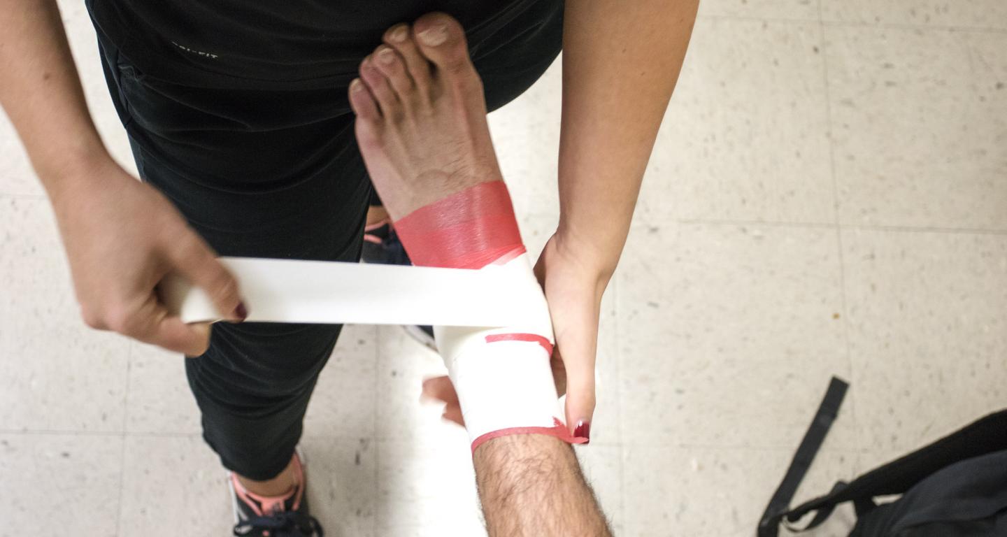 An athletic training student at North Central College wraps a patient's ankle.
