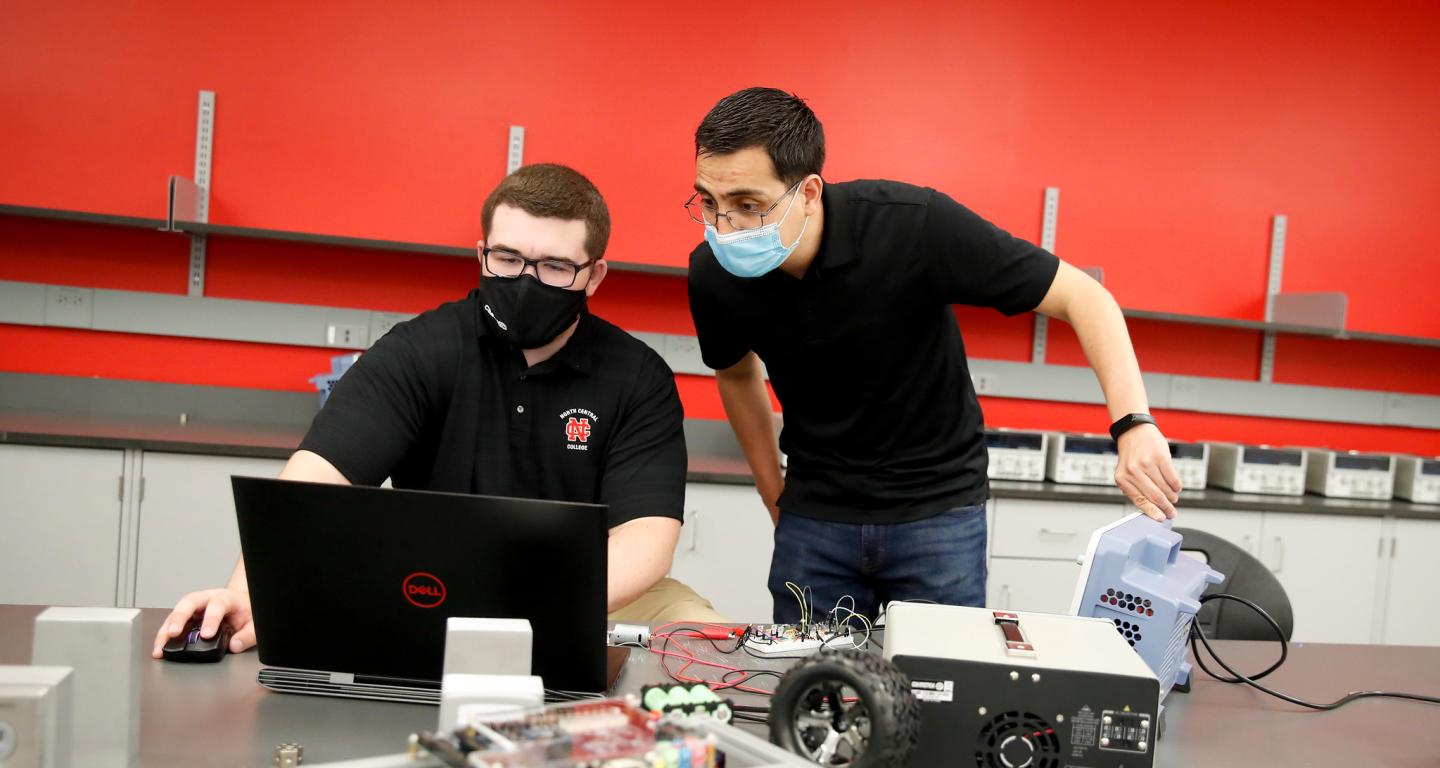 North Central College professor Hector Rico-Aniles works with student William Jandak Jr. on a robotic car.