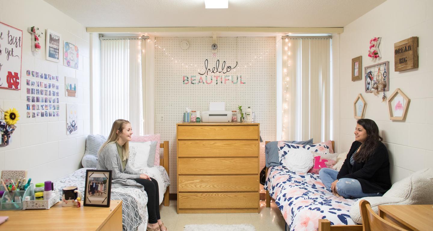 Two North Central College students sitting together in their room.