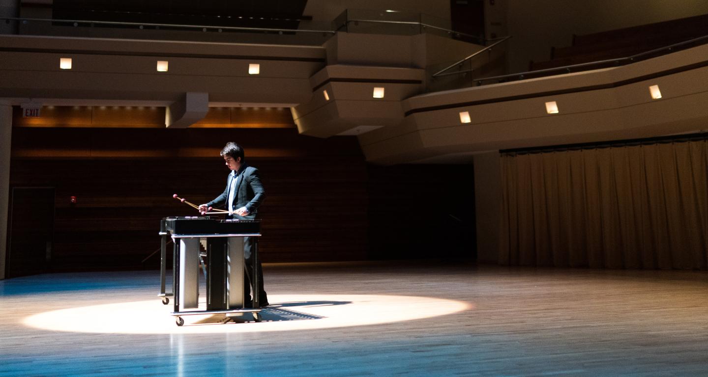 student on stage playing a marimba