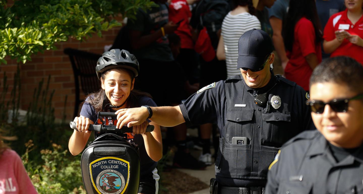 A North Central College campus safety officer doing a demonstration with a criminology student.