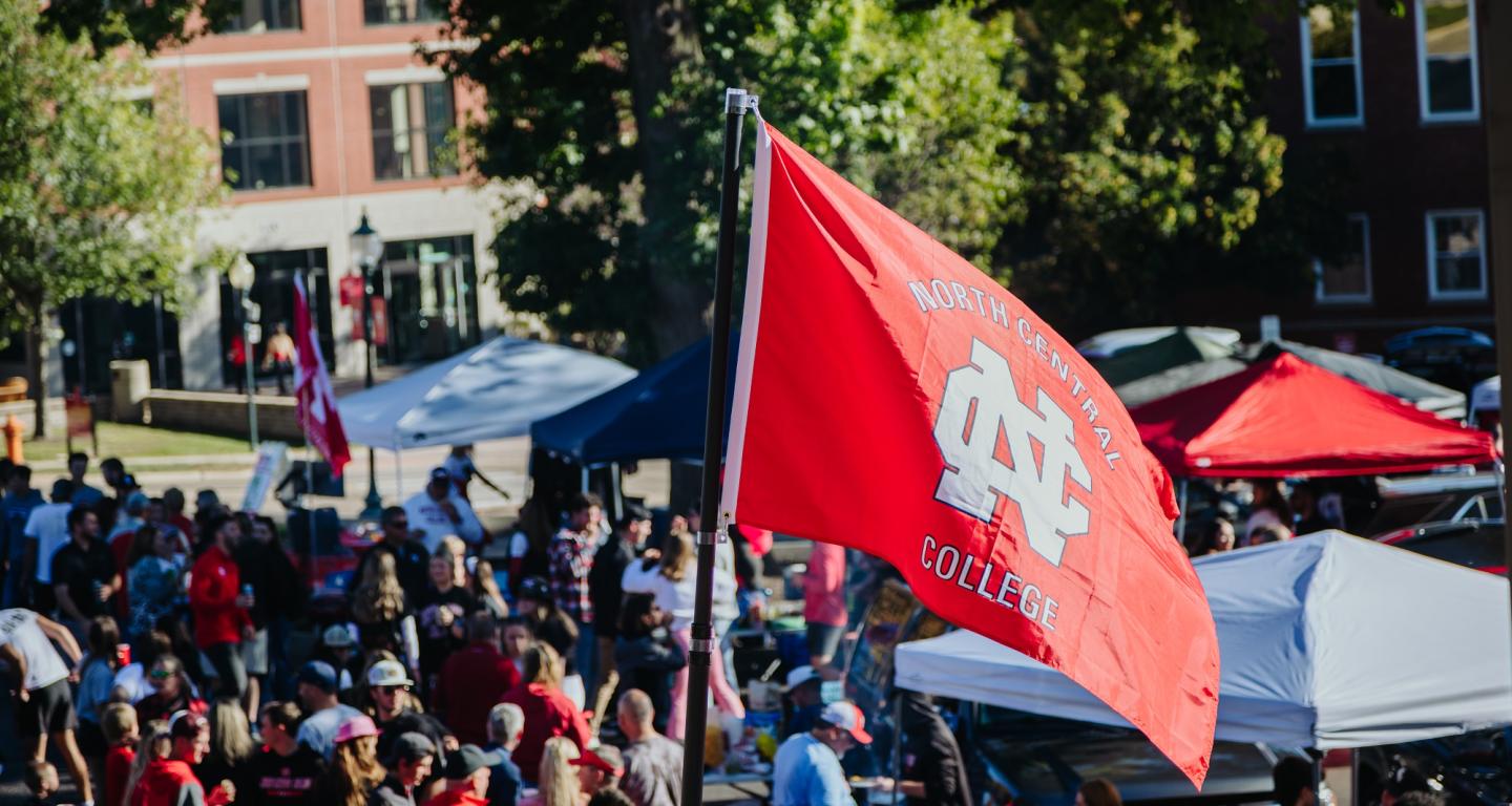 The North Central College flag is held aloft at Homecoming.