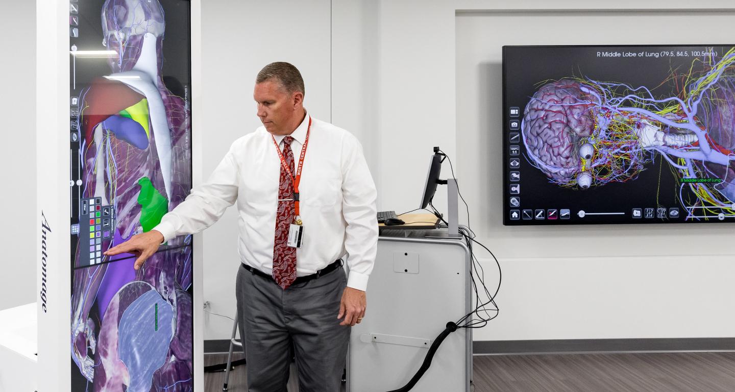 A North Central College professor demonstrates a piece of nuclear medicine technology.