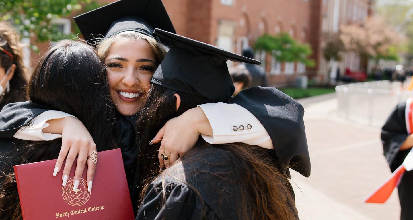 North Central College graduates hugging.