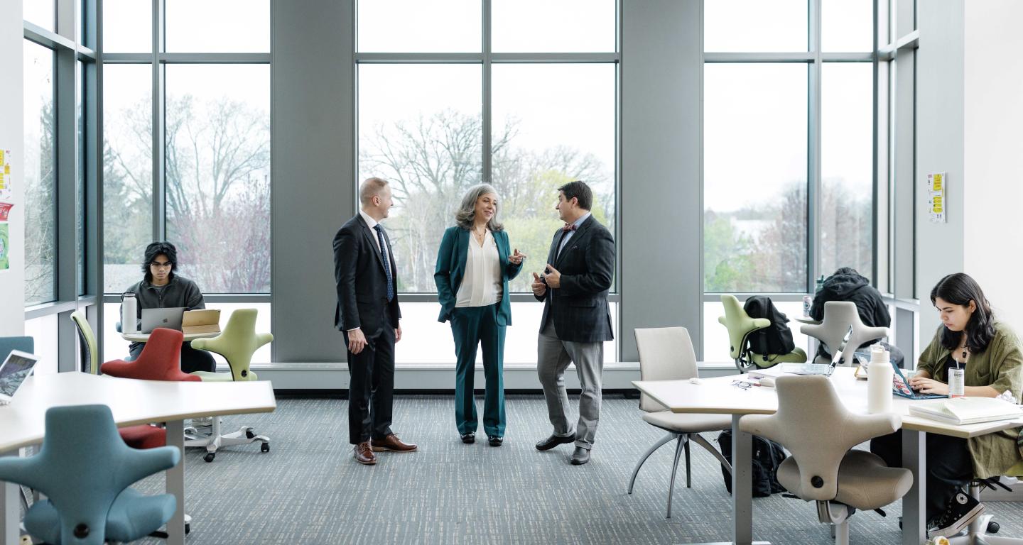 3 Deans talking in academic building.
