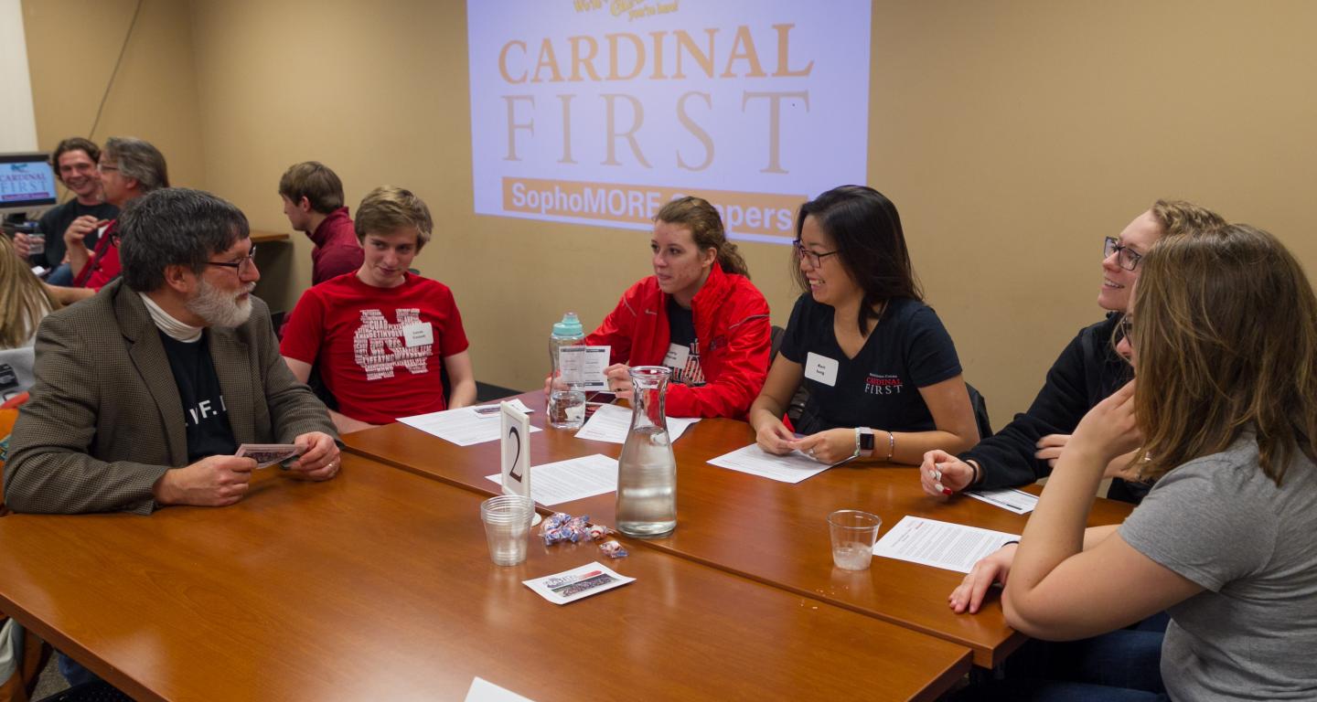 Students discussing the best way to impress professors at a Cardinal First event.