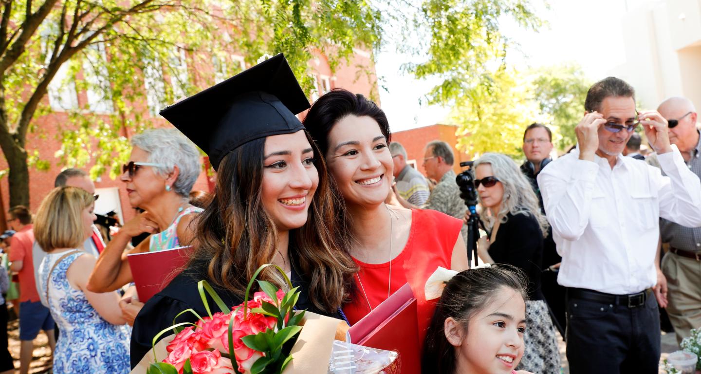 A Cardinal First graduate with her mother and sister at graduation.