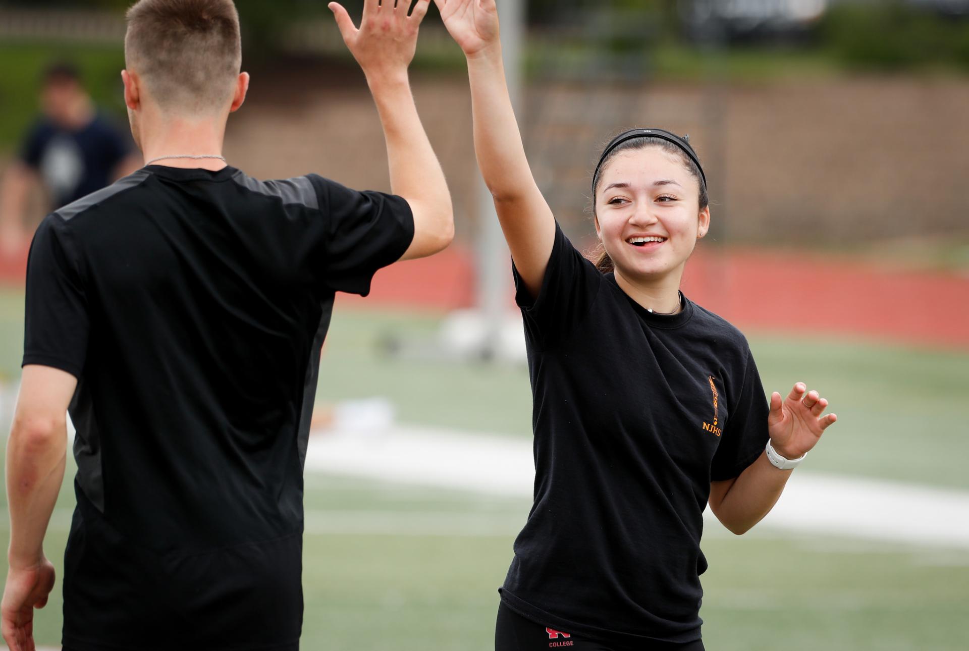 Students high-fiving after winning a roundnet game.