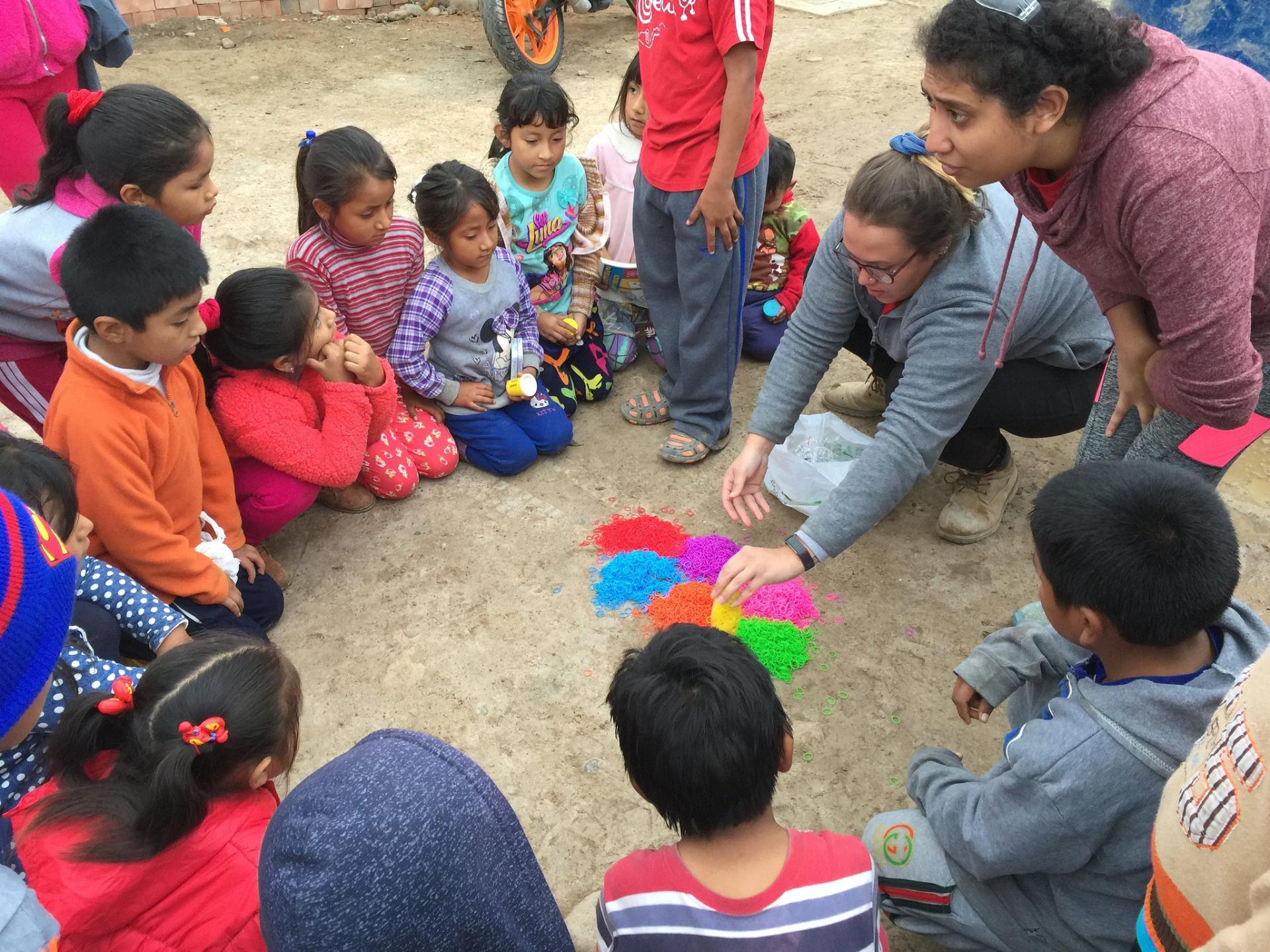 Maria Requena plays a game with children in La Florida.