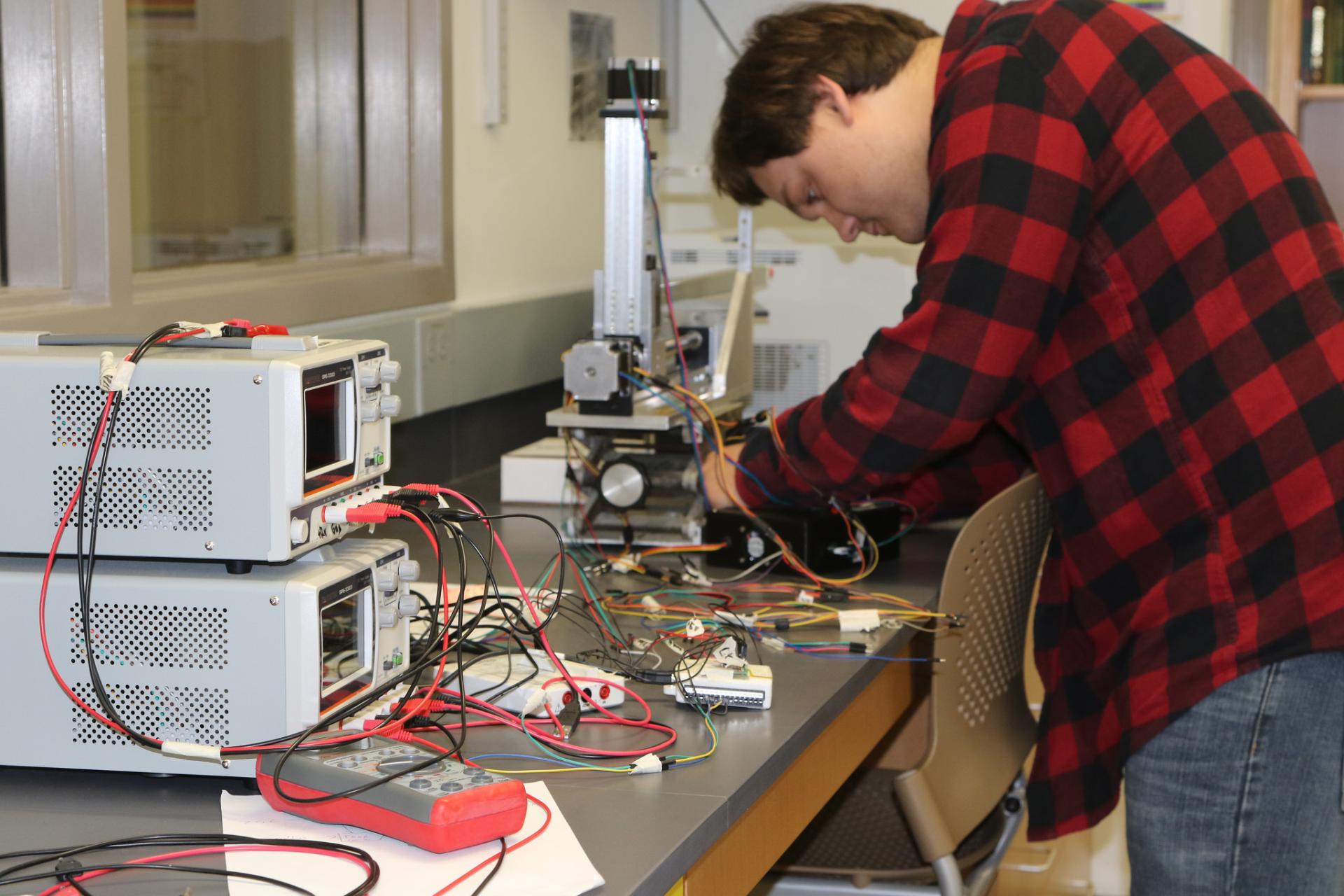 Tyler Weitzel works on the magnetic field-measuring instrument used in the g-2 experiment at Fermi National Accelerator Laboratory.