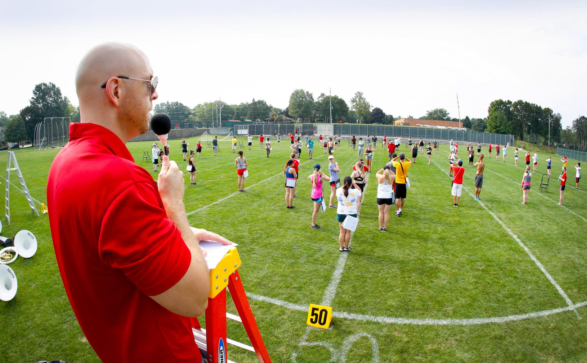 North Central College's Sean Kelley looks out over the marching band perfecting their formations