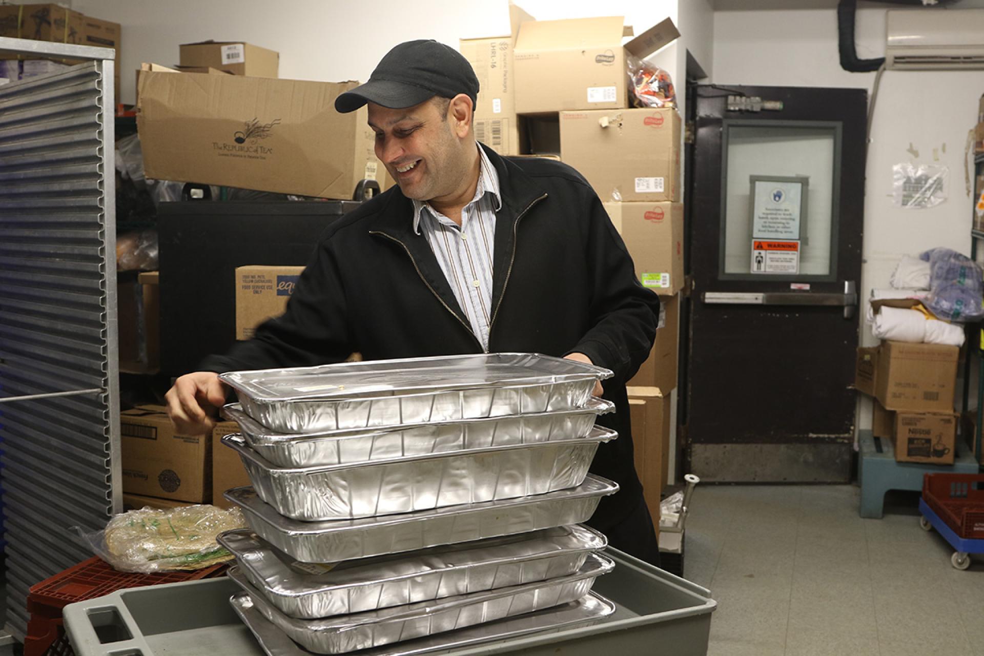 Chartwells employee helps load food for donation.