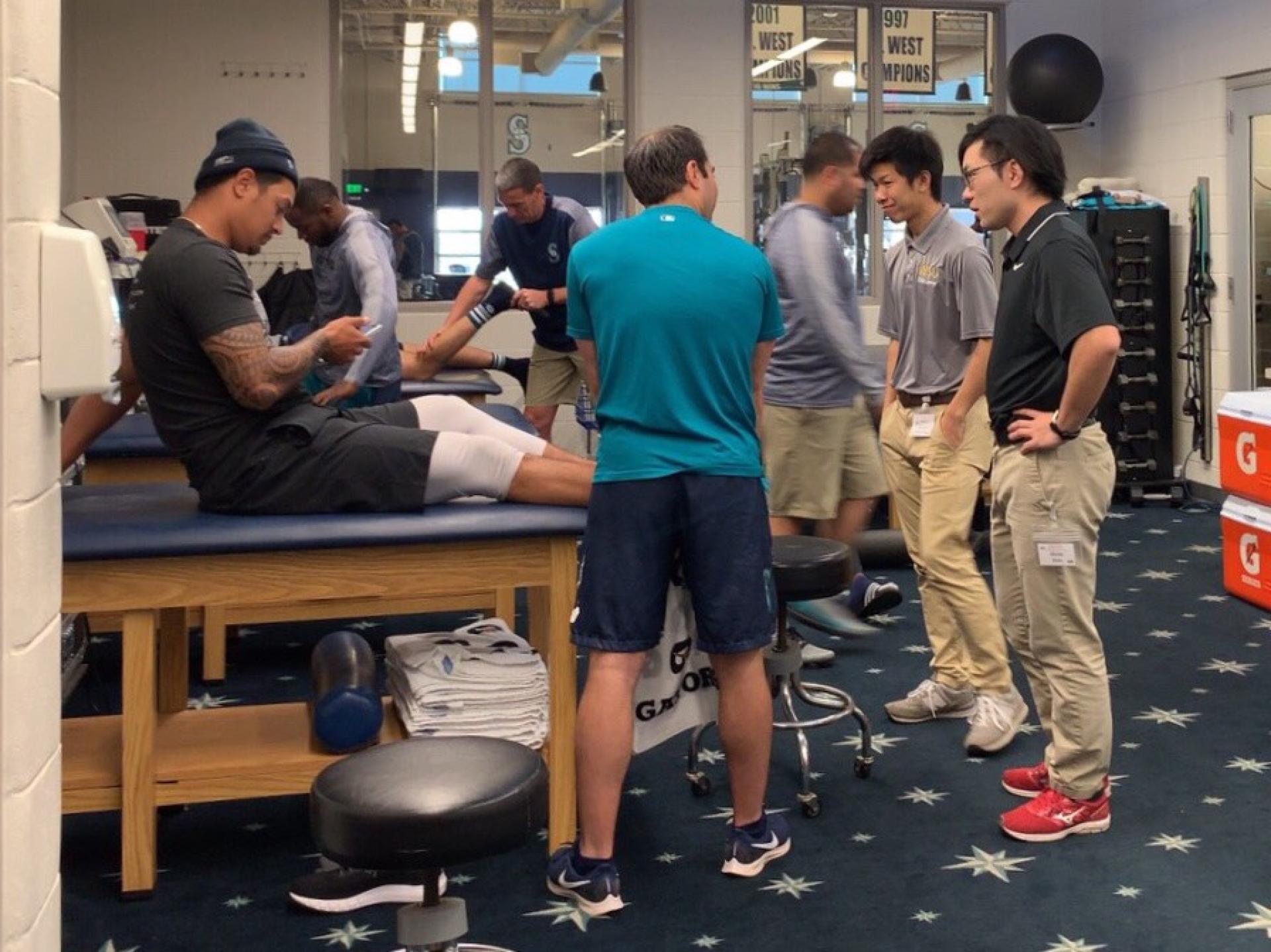 Athletic trainers in the athletic training room with players.