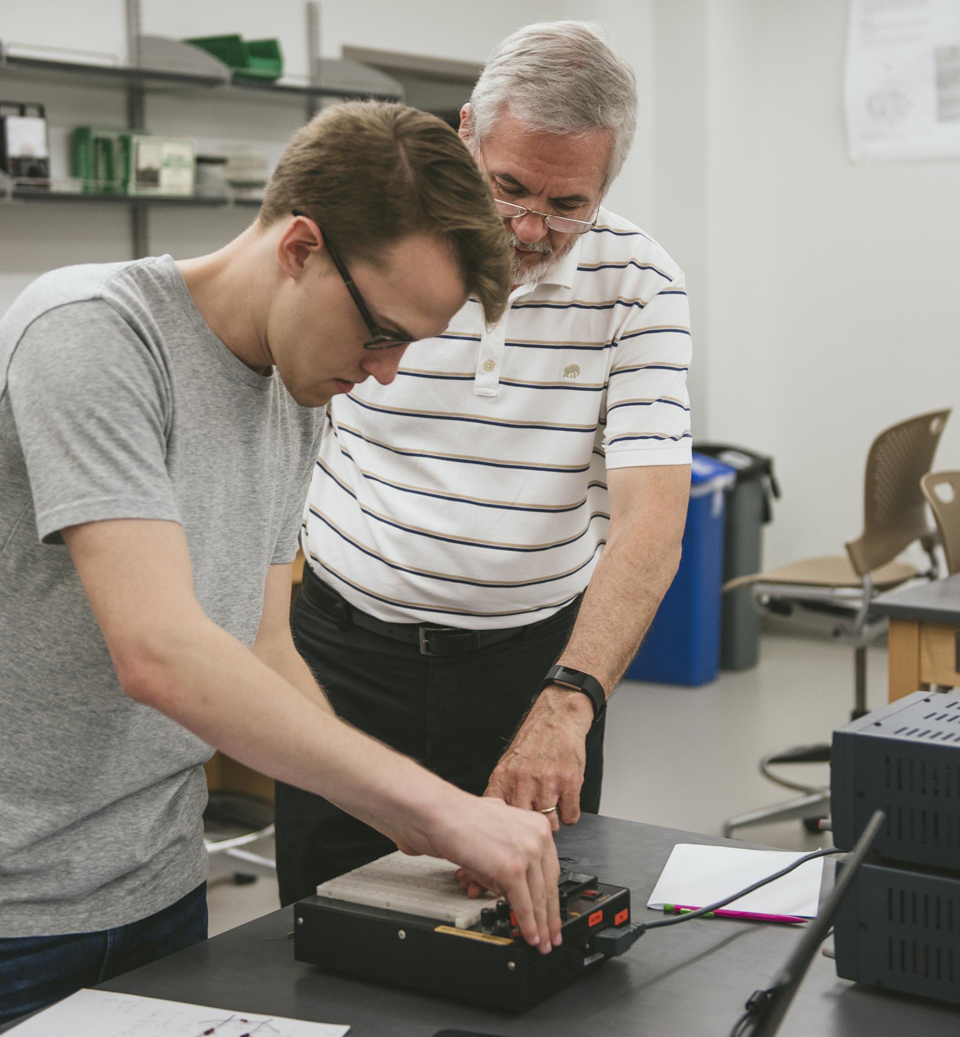 North Central College Professor Frank Harwath helps a student with an engineering project.