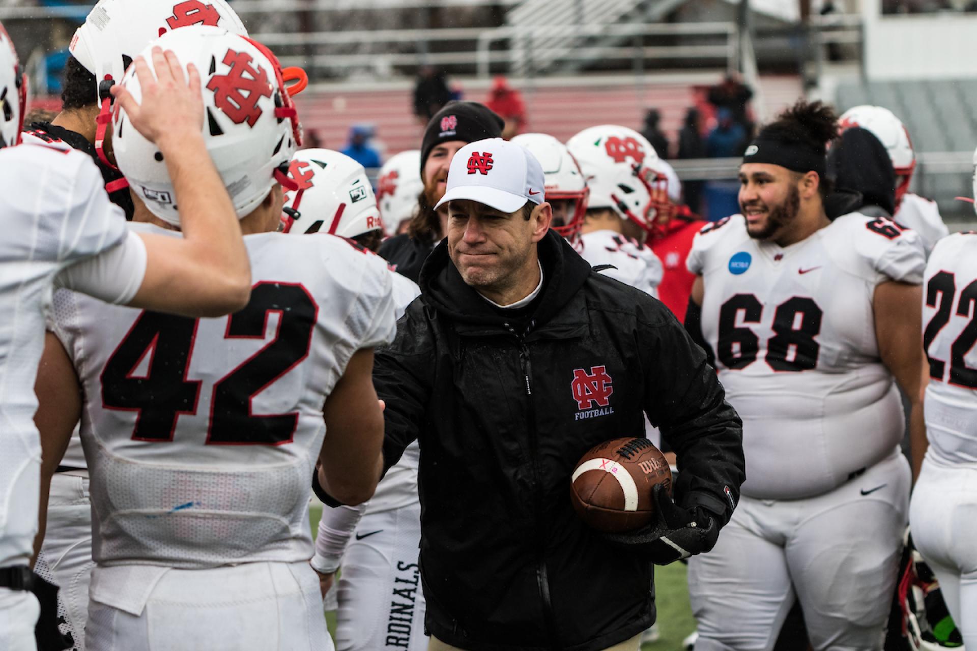 North Central College head football coach Jeff Thorne congratulates his players.