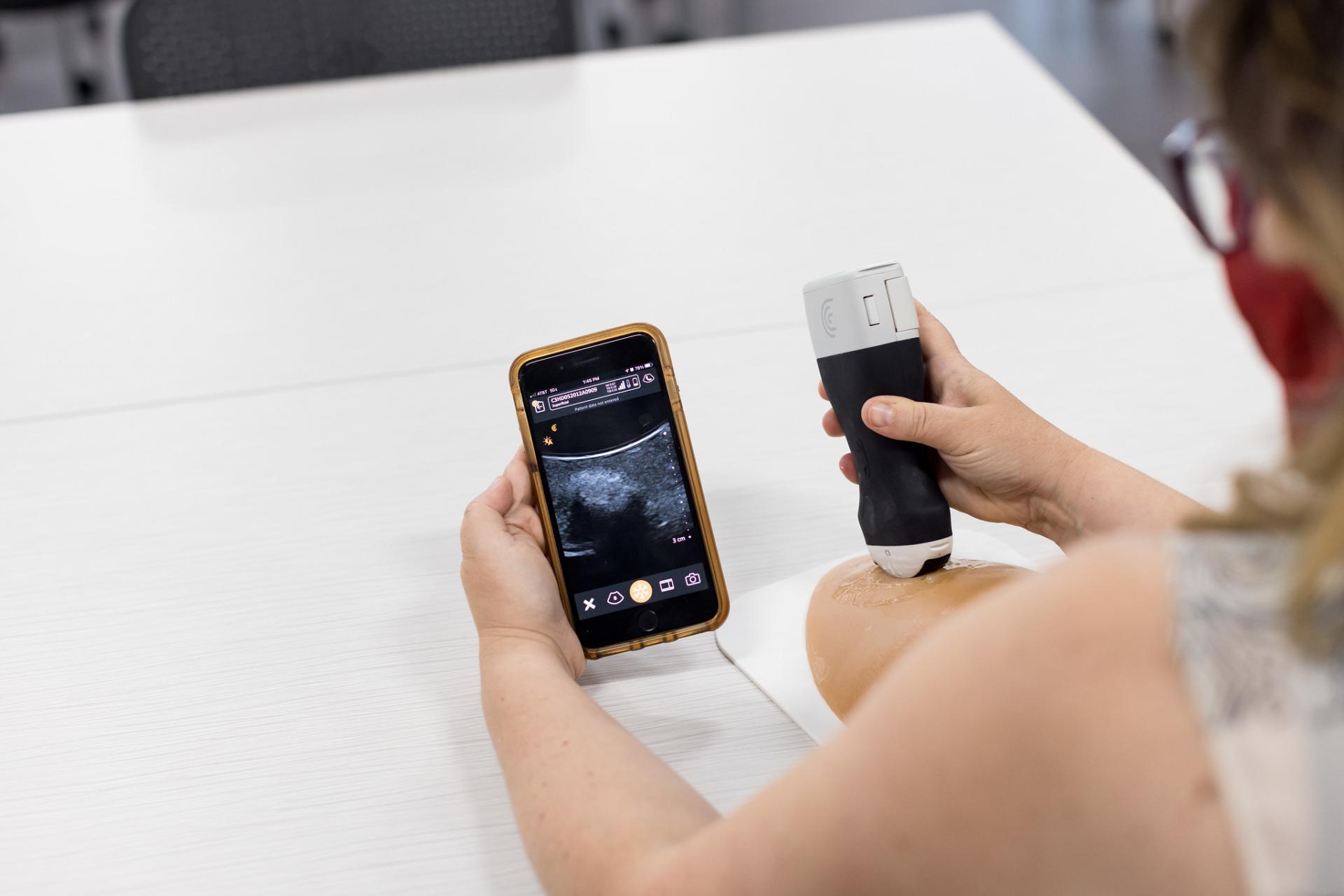 A student uses a Handheld Clarius Ultrasound device.