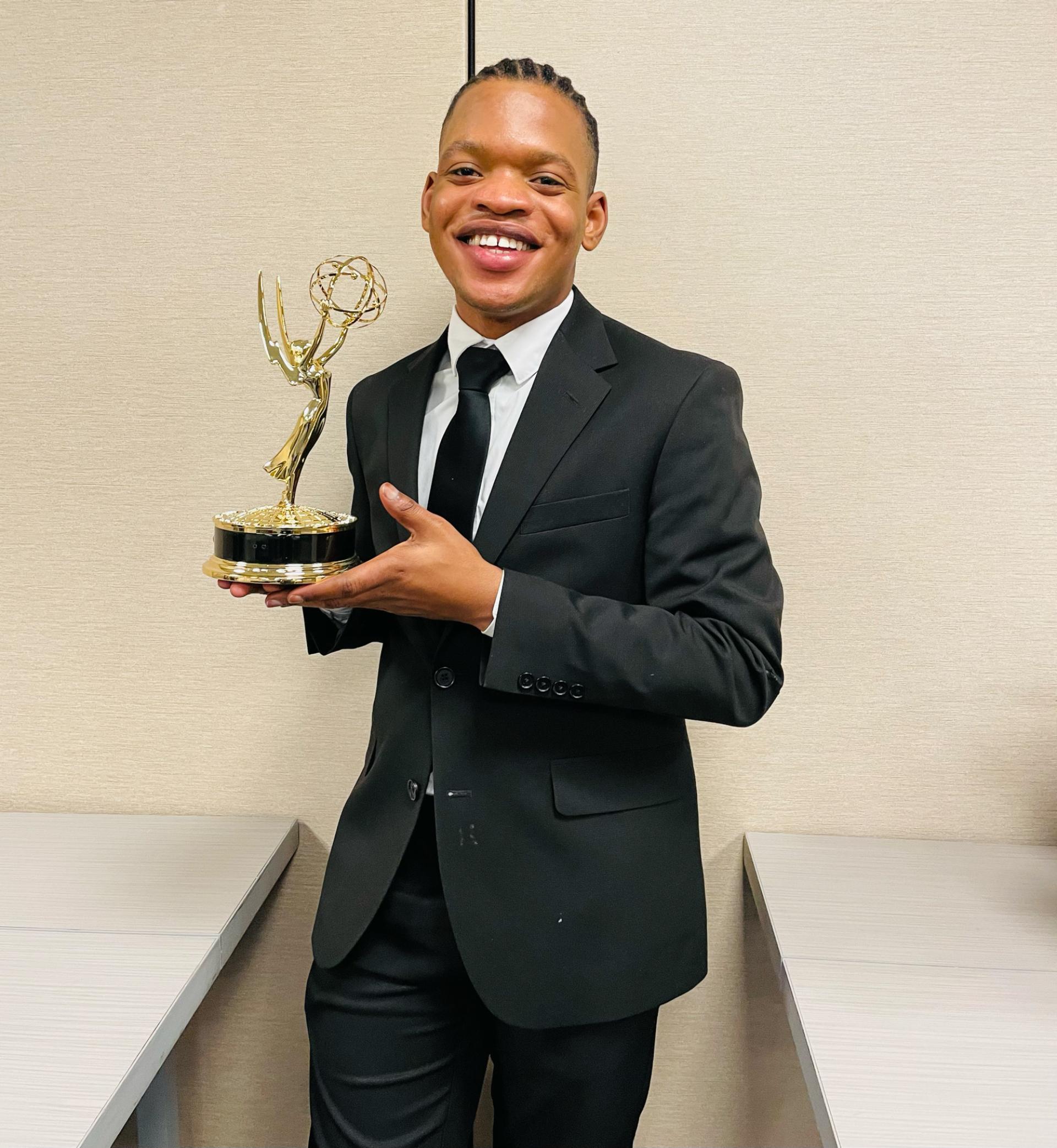 Fredlyn Pierre Louis holding an Emmy statuette.