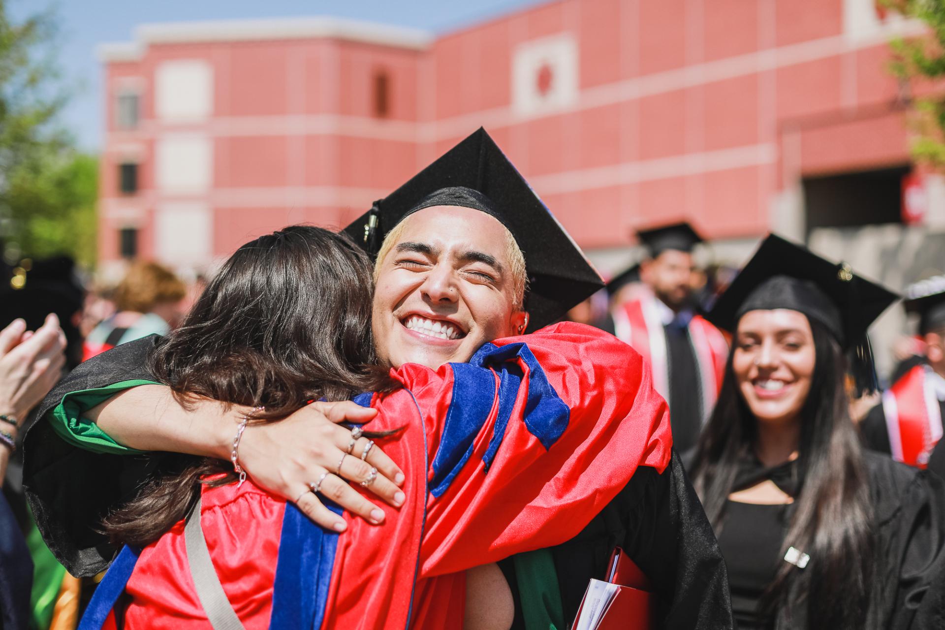 Two North Central College graduates greet one another.