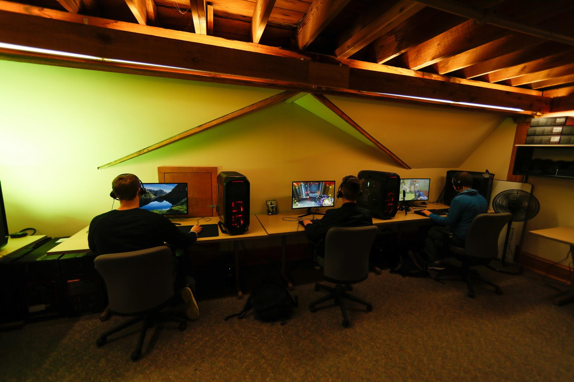 Caleb Lundquist '18, Tom Bochenczak '18 and Brandon Wallace '19 playing video games at computer consoles in the NCC eSports lab.