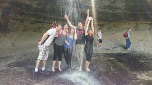 students standing under a waterfall