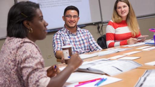 Three students talking during graduate class