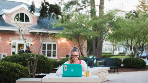 Student studying outside on central campus