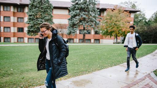 Student walking on campus talking on the phone