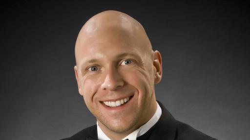 kelley headshot in a tux and a baton 1