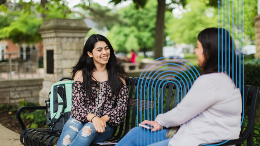 students sitting on a bench in an outdoor courtyard